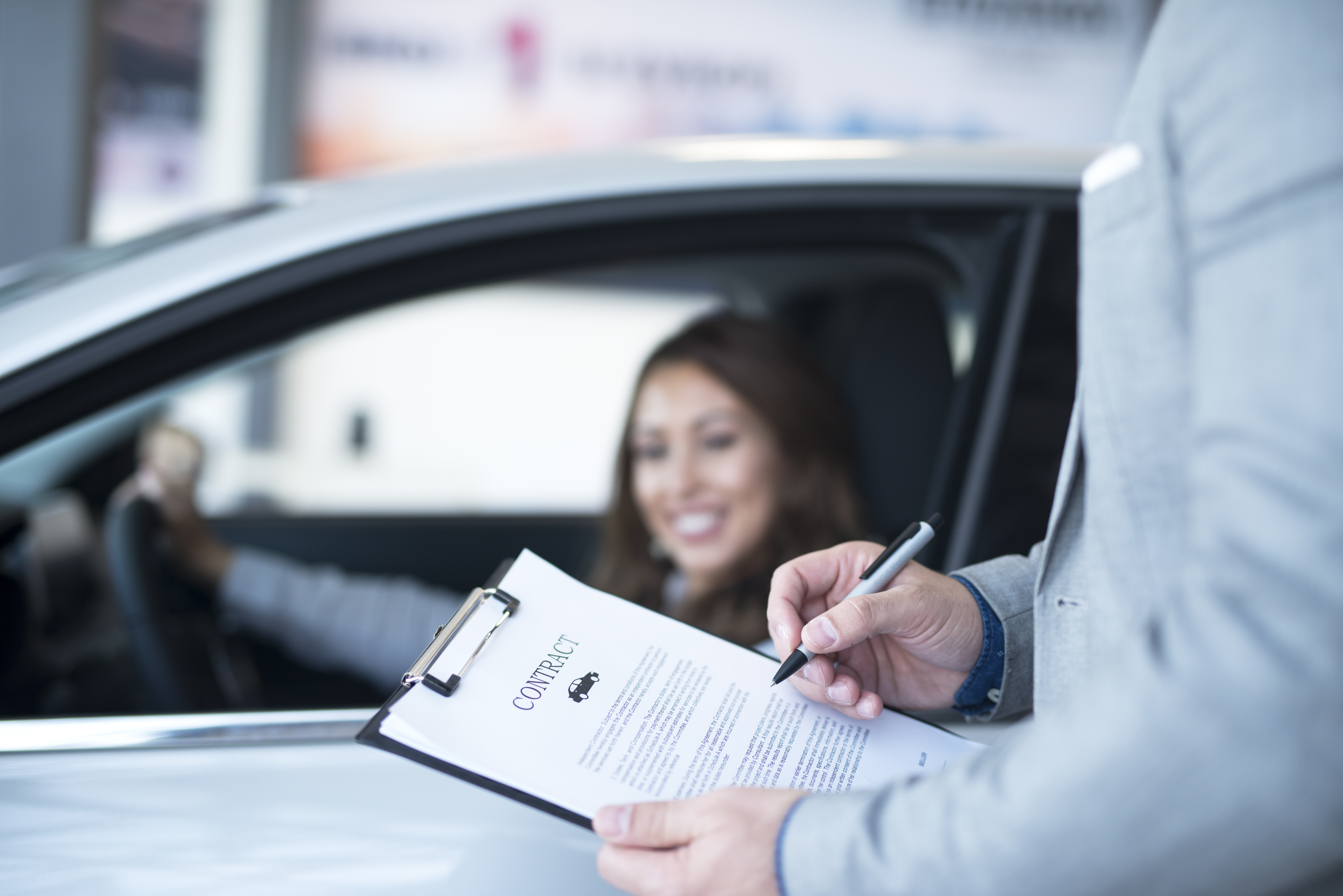 Femme dans une voiture et homme avec un contrat en main